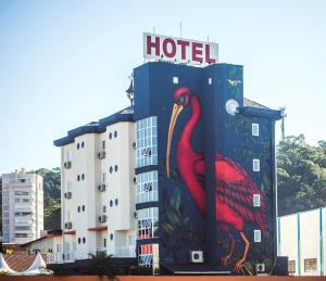 a building with a painting of a red bird on it at Andardac Hotel in Guaramirim