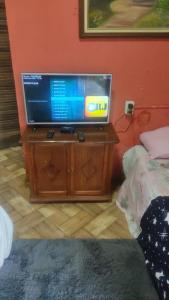 a television on a wooden stand in a room at Kitnet Da Cláudia e Geovani in Miguel Pereira