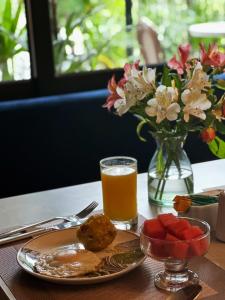 ein Tisch mit einem Teller Essen und einem Glas Orangensaft in der Unterkunft Manakin Hostal & Resto in Manta