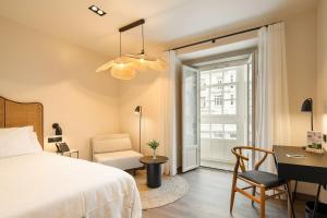 Un dormitorio con una cama, un escritorio y una silla. en Sercotel EsteOeste, en Lugo