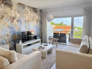 a living room with a couch and a tv at Serene View - By SCH in Alvados