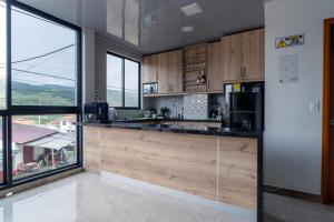 a kitchen with wooden cabinets and a large window at Hotel Plaza Real Oiba in Oiba