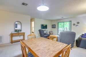 a living room with a wooden table and chairs at Bella Vista Townhome with Deck Near Back 40 Trail! in Bella Vista