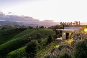 a house on top of a green hill at Pousada Casa Bambu in Cunha
