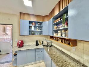 a kitchen with blue cabinets and a counter top at Apartamento no centro com varanda e vaga de garagem in Nova Friburgo