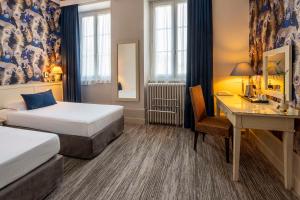 a hotel room with two beds and a desk at Best Western de Diane in Nevers