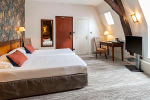 a hotel room with a large bed and a desk at Best Western de Diane in Nevers