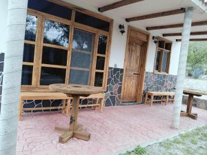 a patio with a wooden table and benches in front of a building at Cabañas Los Olivos in Ixmiquilpan +34 photos