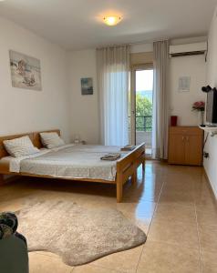 a bedroom with a large bed and a large window at Sunny Bay Apartments in Španjola