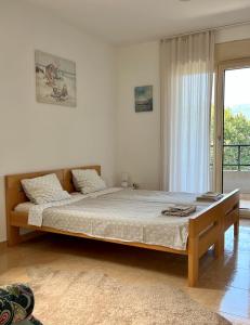 a bedroom with a large bed in front of a window at Sunny Bay Apartments in Španjola +26 photos