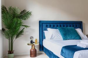 a blue bed with white pillows and a plant at ALFANI DUOMO Suite in Florence