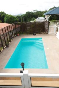 a large blue swimming pool on a patio at bas de villa splendide in Rivière-Salée +4 photos