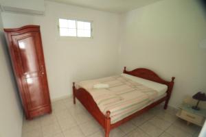 a small bedroom with a bed and a window at bas de villa splendide in Rivière-Salée
