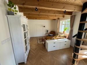 a living room with a white cabinet and a window at Curry House Apartment in Seyðisfjörður