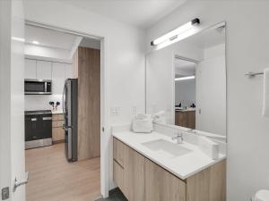 La salle de bains blanche est pourvue d'un évier et d'un réfrigérateur. dans l'établissement Global Luxury Suites at Downtown Phoenix, à Phoenix