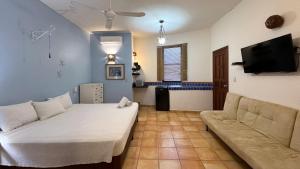 a living room with a bed and a couch at Departamentos en SF - Adults Only in Playa del Carmen