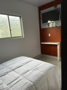 a bedroom with a bed and a flat screen tv at Hotel Boutique La Caballeriza in Quillacollo +35 photos