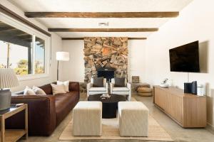 sala de estar con sofá y chimenea de piedra en Casa Cholla- Game Room, Hot Tub, Plunge Pool, Sauna, Hammocks, en Yucca Valley