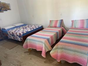 a room with two beds and a bedskirts at Pousada Chalés Praia Vermelha in São João Batista do Glória