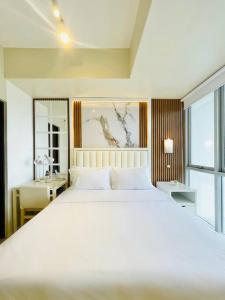 a bedroom with a large white bed and a desk at 14 Skyline Serenity in Iloilo City