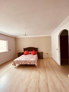a bedroom with a bed with red pillows on it at La cigale in El Jadida