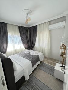 a bedroom with a bed and a window with curtains at Gökçen Home in Pamukkale +22 photos