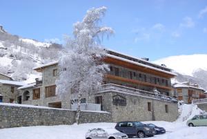 a building with cars parked in the snow at Hostal La Cabanya in Setcases