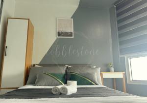 a bedroom with a bed with towels on it at Cobblestone Properties - SM Mezza 1 Residences in Manila +10 photos