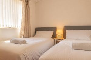 two beds sitting next to each other in a bedroom at 5 Ocean View in Woolacombe