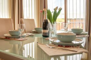 a glass table with a bottle of wine and a table with glasses at 5 Ocean View in Woolacombe