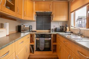 a kitchen with wooden cabinets and a stove top oven at 5 Ocean View in Woolacombe +12 photos