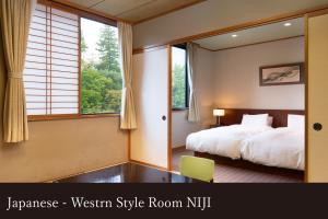 a bedroom with a bed and a large window at Yamanaka Onsen Kagari Kisshotei in Kaga
