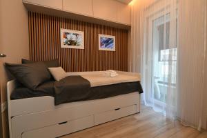 a small bedroom with a bed with a window at Metropolitan Royal in Jagodina