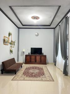 a living room with a couch and a flat screen tv at Acc Family Homestay in Takengon