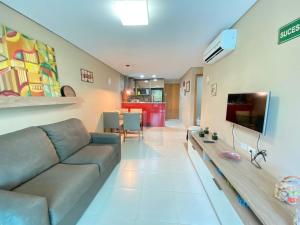 uma sala de estar com um sofá e uma TV em Carneiros Beach Resort apto 208A em Praia dos Carneiros