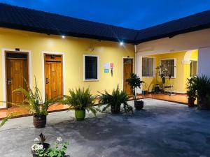 a yellow building with potted plants in a courtyard at ACCEL Hotel La Quinta in Ibarra