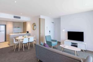 sala de estar con sofá y TV y cocina en beach residence 2-BR river view, en Gold Coast