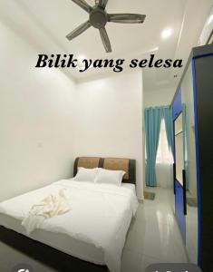 a bedroom with a bed with a ceiling fan at 3A HOMESTAY USTAZ Krai in Kuala Kerai