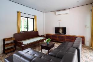 a living room with a couch and a flat screen tv at Pastela Doi Saket Villa & Spa in Ban Pong