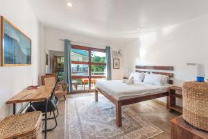 Un dormitorio con una cama, una mesa y un escritorio. en Fat Lips Surf Lodge, en General Luna