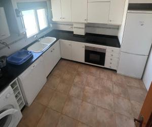 a kitchen with white cabinets and a sink and a dishwasher at Apartamento Rey I in Valencia