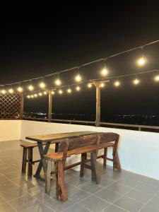 a wooden table and bench on a rooftop with lights at Nhã Hotel in Phan Rang–Tháp Chàm +18 photos
