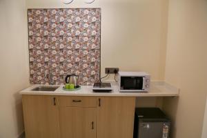 a kitchen with a sink and a microwave on a counter at Lumis studio apartment in Hyderabad
