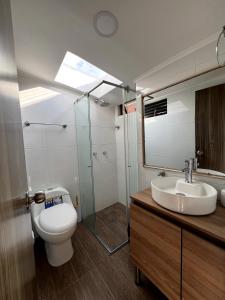 a bathroom with a toilet and a sink and a mirror at Lindos Apartamentos con Terraza in Manizales