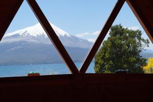 a view of a snow covered mountain from a window at Cabañas Domos May-Ling in La Ensenada