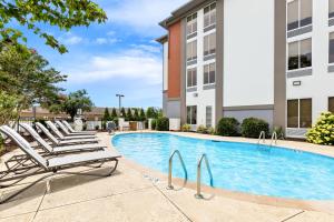 a swimming pool with lounge chairs next to a building at Holiday Inn Express Nashville-Hendersonville by IHG in Hendersonville