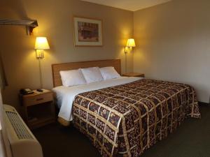 a hotel room with a bed and two lamps at Executive Inn Kilgore in Kilgore