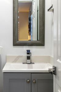 a bathroom with a white sink and a mirror at Cozy Apartment with a luxury King Bed in Miami Gardens +43 photos