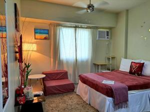 a hotel room with a bed and a chair at GEM Condotel by JamYatz homestay Amaia Altaraza in Tunkong Manga +20 photos