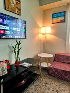 a living room with a couch and a tv at GEM Condotel by JamYatz homestay Amaia Altaraza in Tunkong Manga